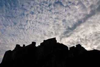 A mysterious castle silhouetted against a stormy sky.