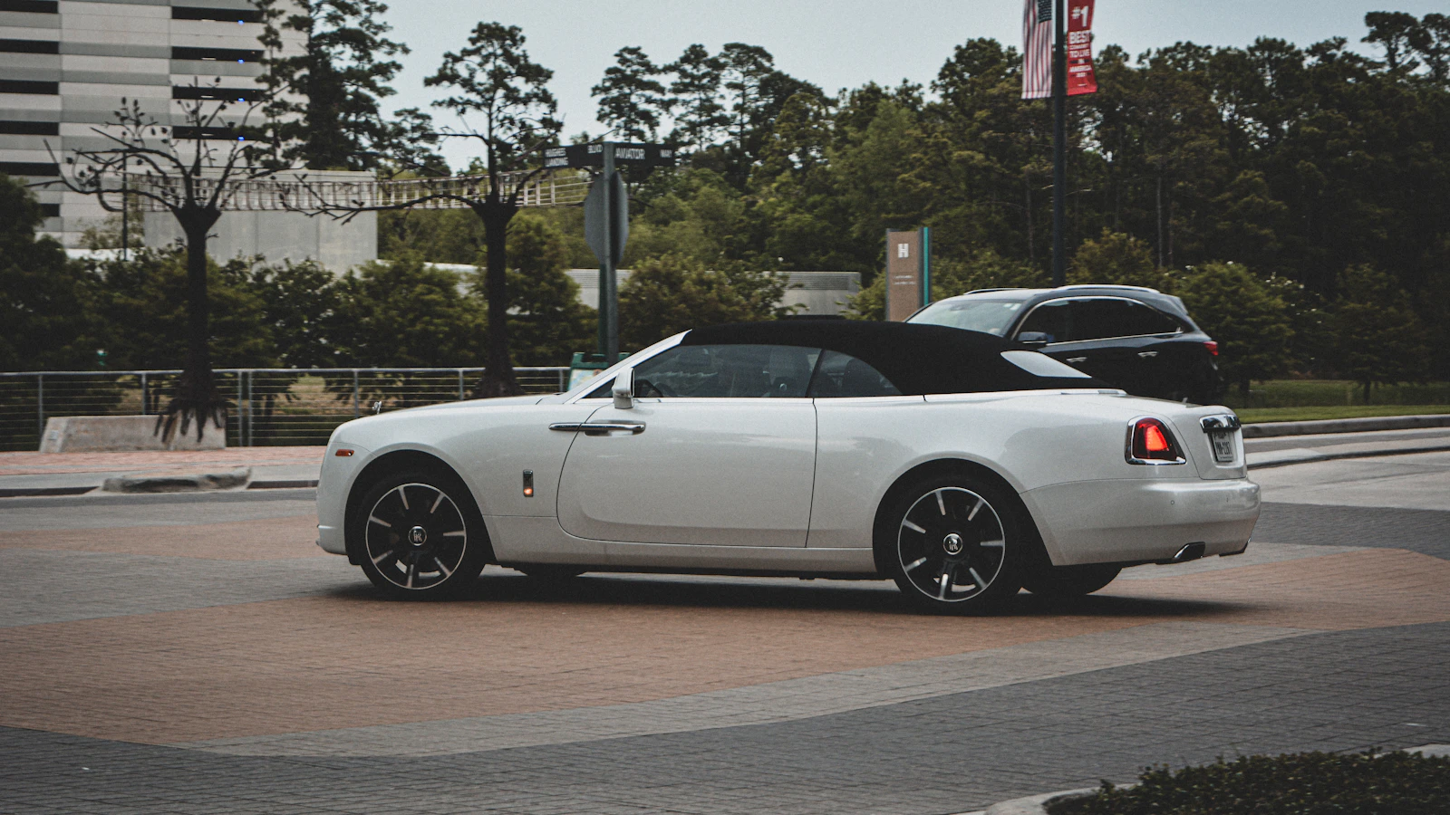 White Rolls-Royce Dawn convertible with its black soft top up