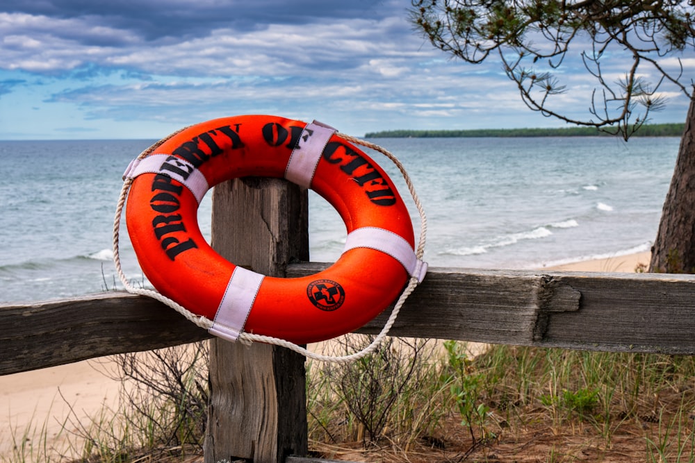 a life preserver on a wooden fence by the beach