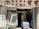 A small convenience store entrance with a curtain partially covering the doorway. The store has a variety of goods including bottled water, drinks, and household items. The signage above the entrance includes both Chinese characters and English text.