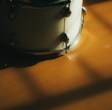 Close-up of a vibrant drum kit with polished wood and shining cymbals under warm studio lights.