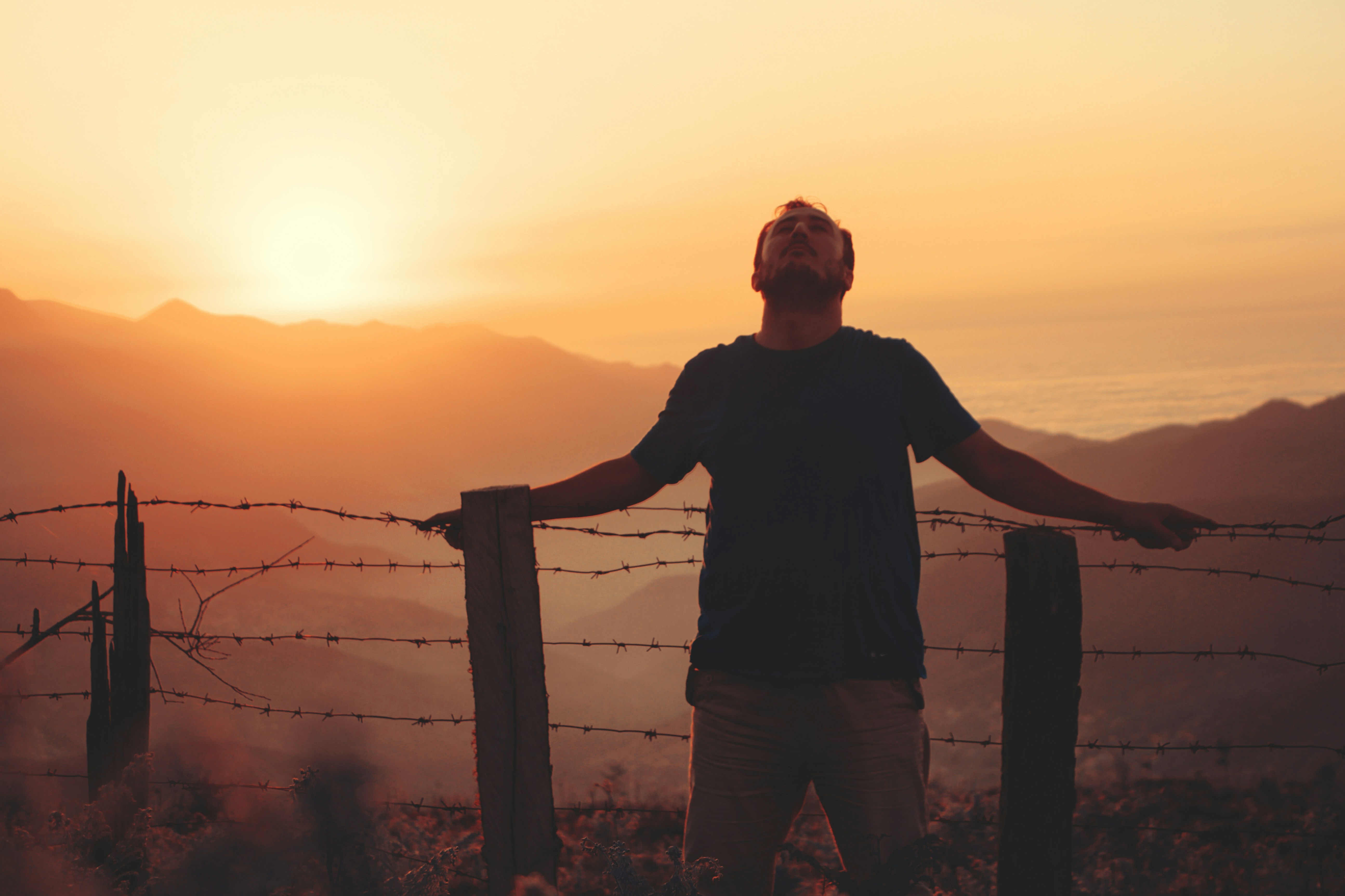 a man standing by a fence, Tired but at the top