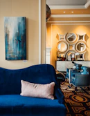 A sleek, modern living room with deep navy walls and plush velvet furniture highlighted by golden decorative pieces.