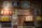A nostalgic collection display featuring vintage-style items against a brick wall. The display includes several retro advertisements and signs in Chinese and Japanese characters, jars filled with candy, old-fashioned milk tins, a mannequin in a toy box, and a decorative straw hat.