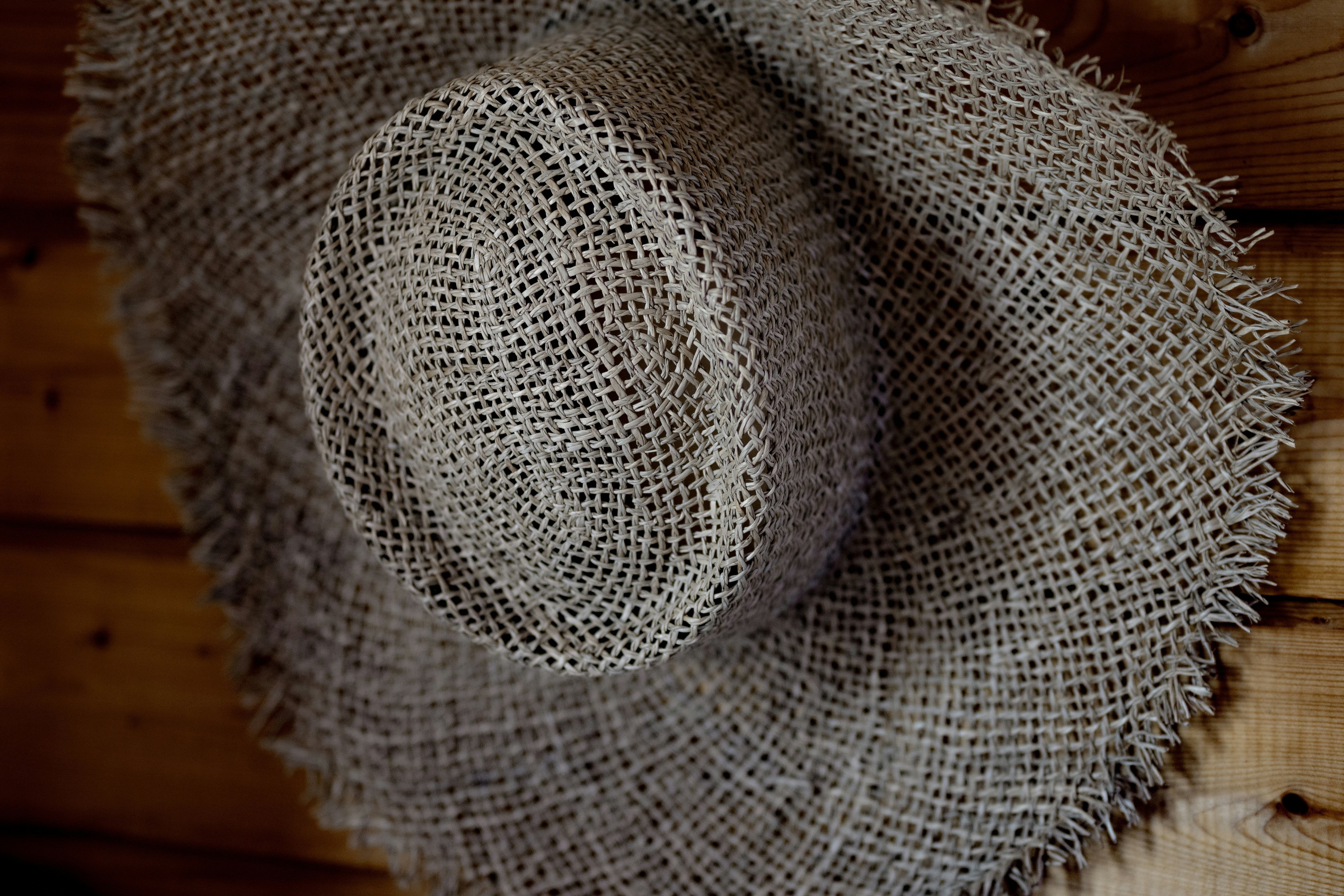 A straw hat is hanging on the wall