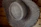 Close-up of a stylish hat resting on a wooden table with soft natural light