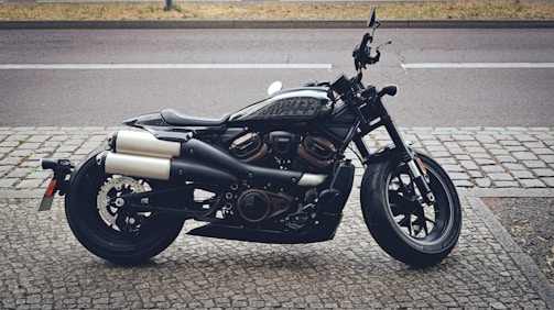 Sleek black motorcycle parked beside a city street.