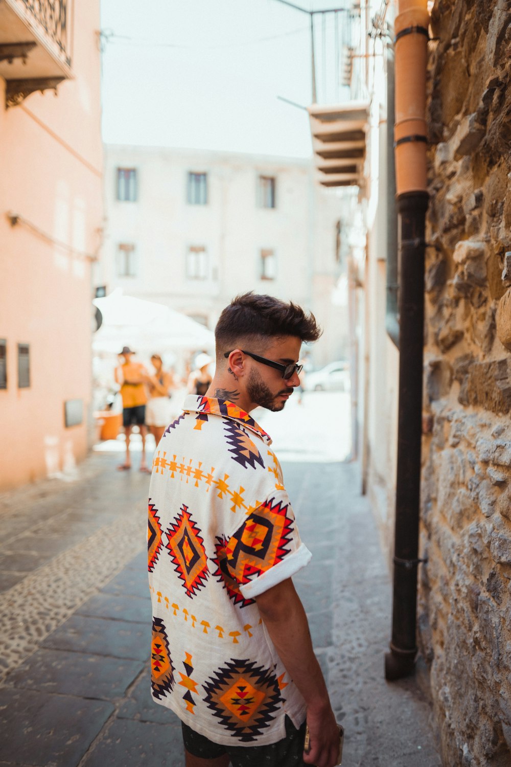 a person wearing a yellow shirt and sunglasses standing on a street