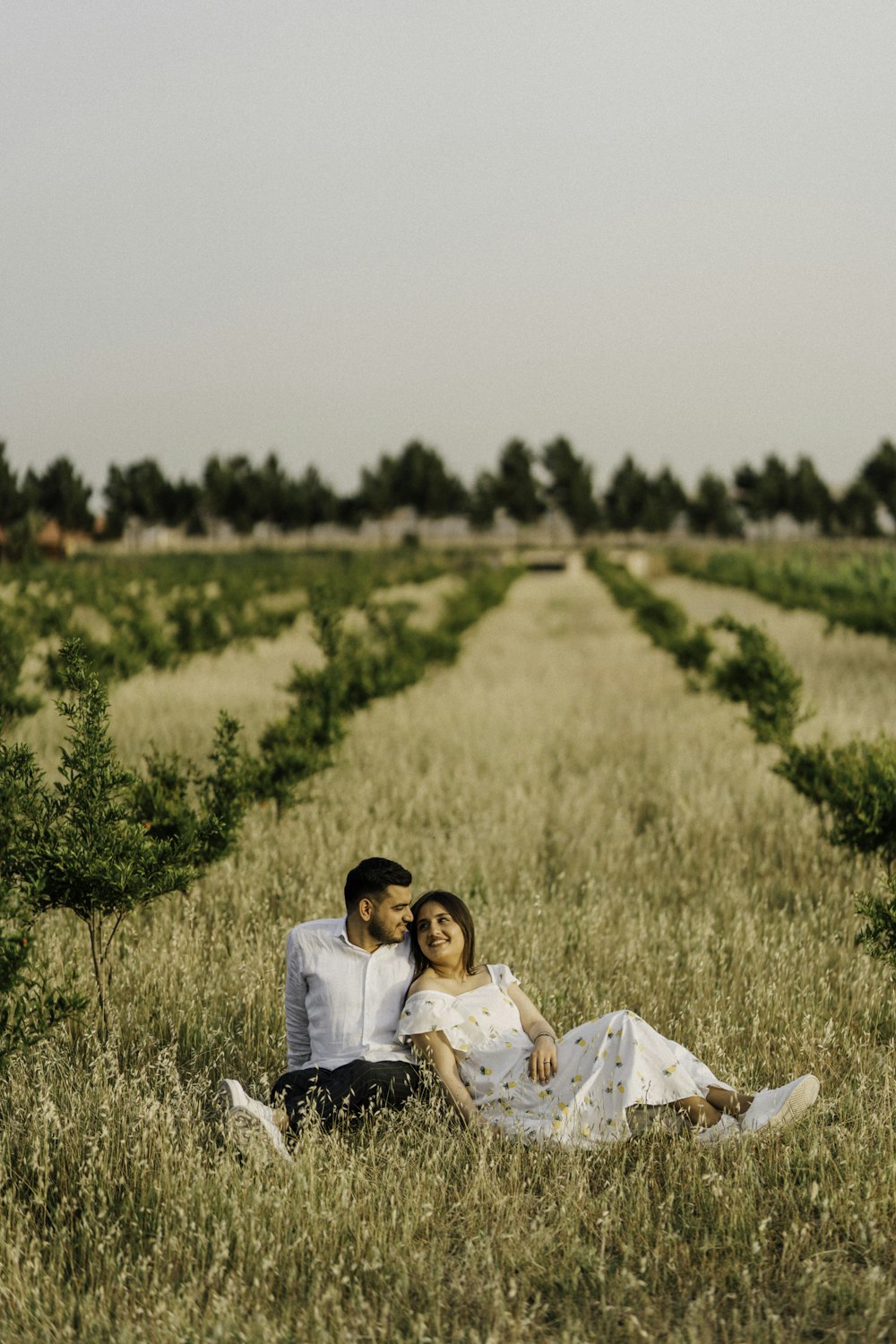 a man and woman sitting in a field