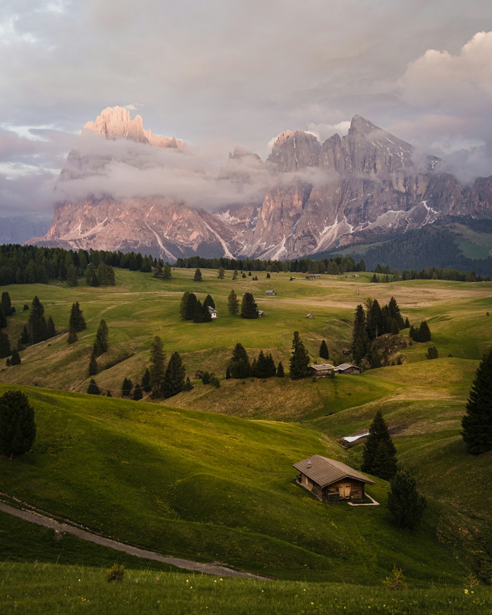 a house in a valley with a mountain in the background