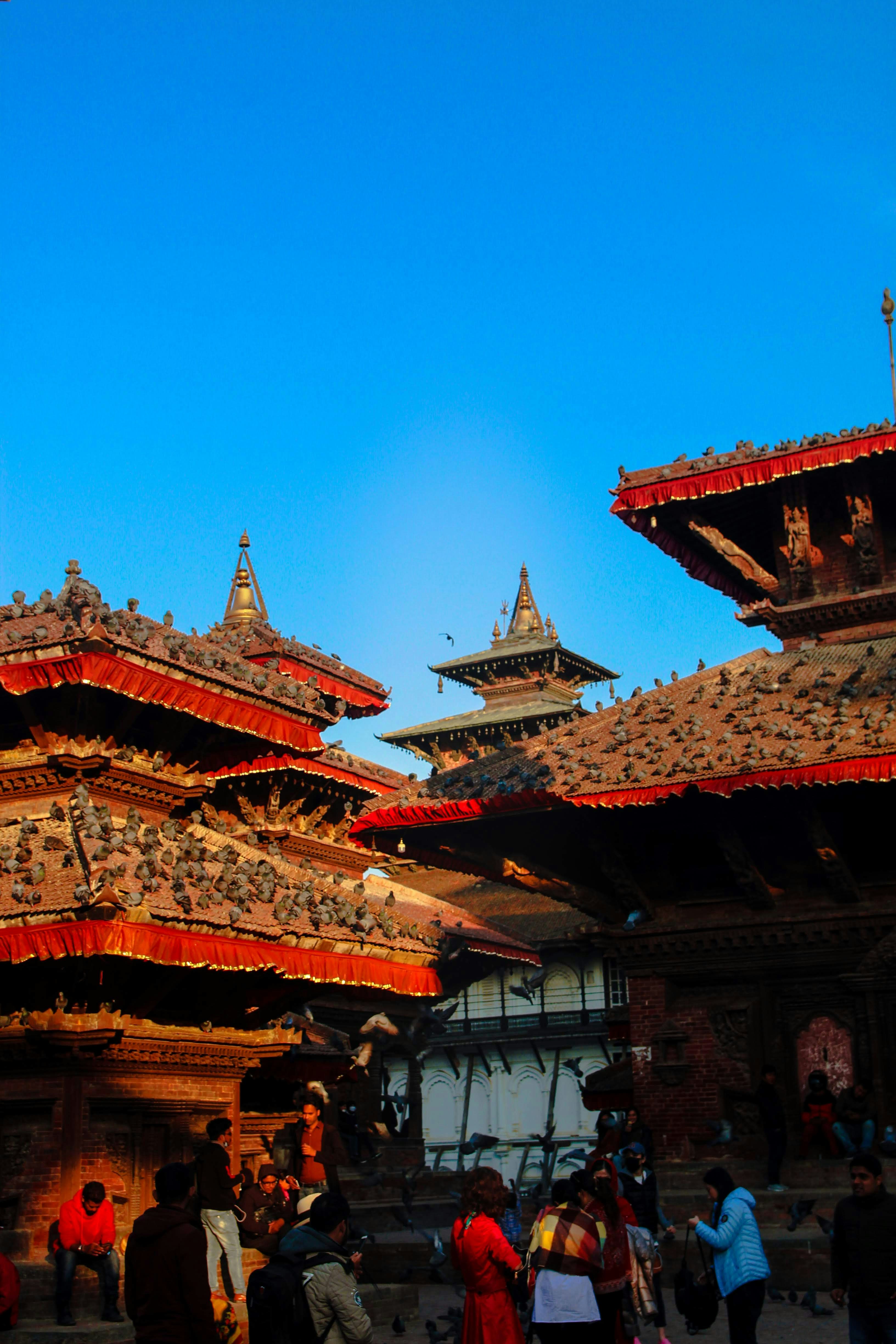 a group of people walking around a building with asian architecture