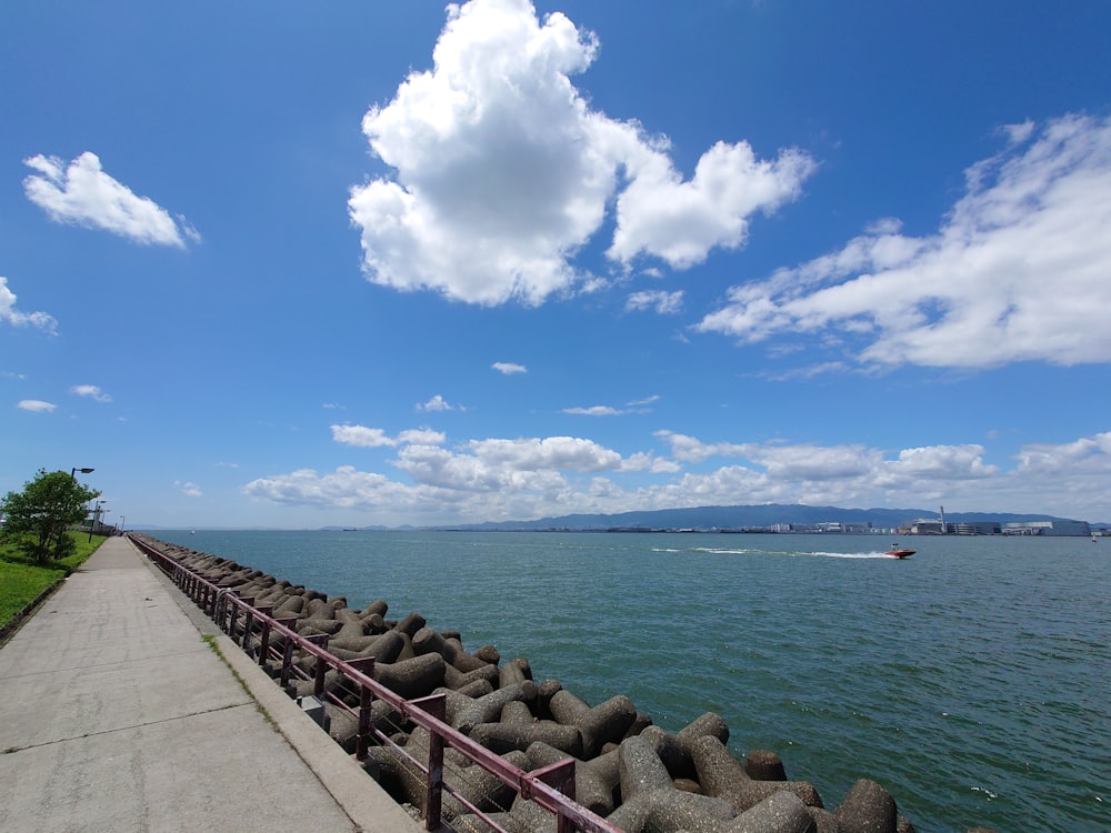 a path leading to a body of water with a walkway and rocks