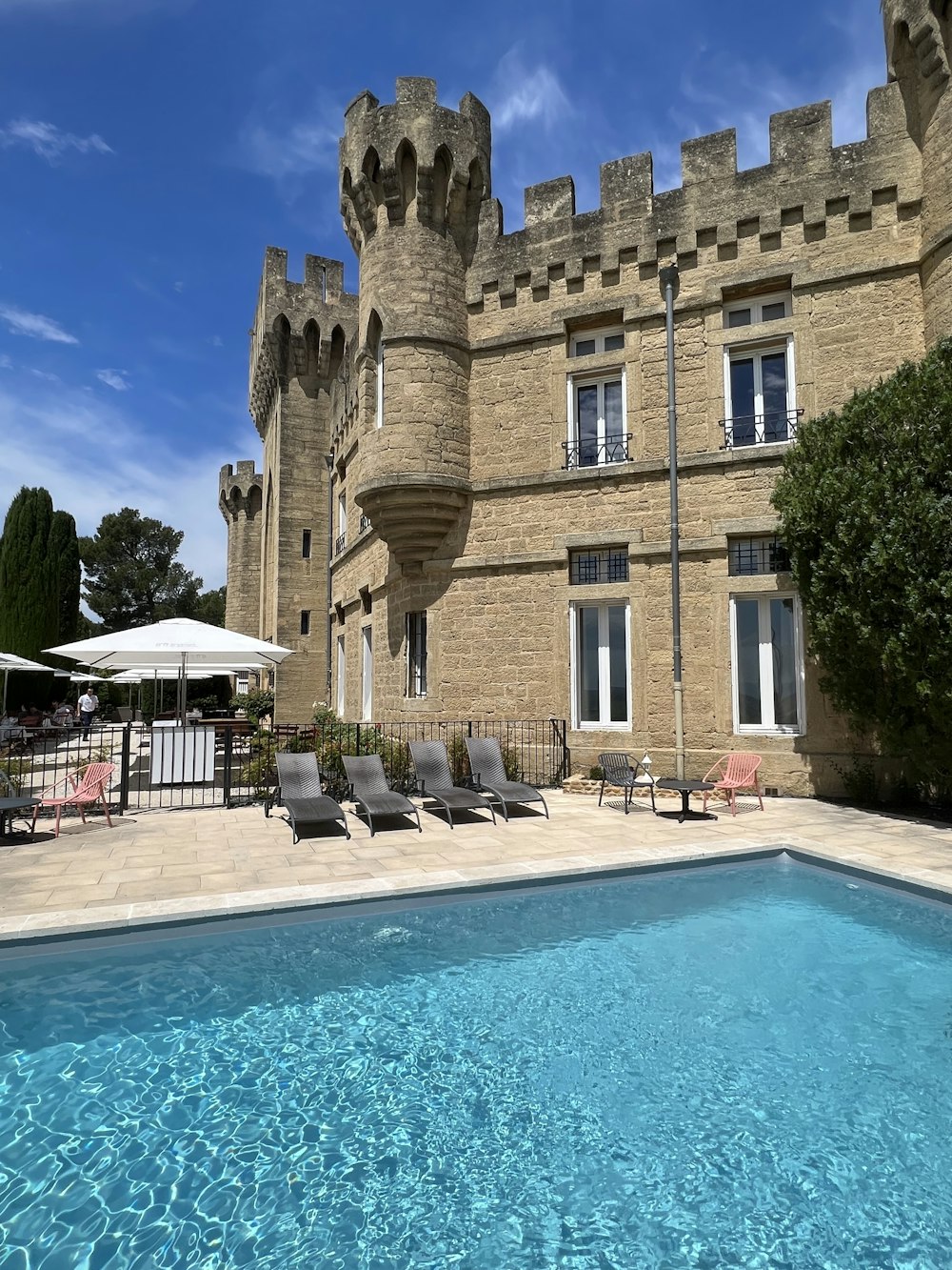 a pool in front of a stone building