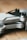 A close-up view of a folded drone with the label 'MINI 2' visible on its arm. The design is sleek with a combination of matte gray and black surfaces, lying on a wooden surface.