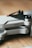 A close-up view of a folded drone with the label 'MINI 2' visible on its arm. The design is sleek with a combination of matte gray and black surfaces, lying on a wooden surface.