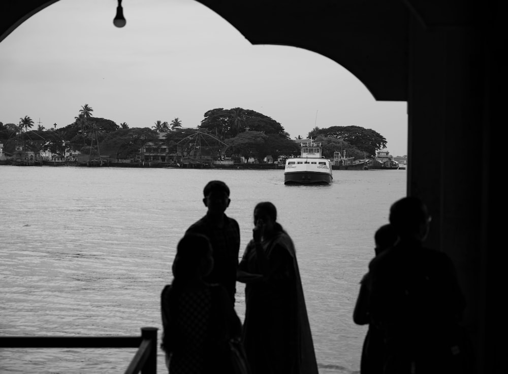 a group of people looking out a window at a boat on the water