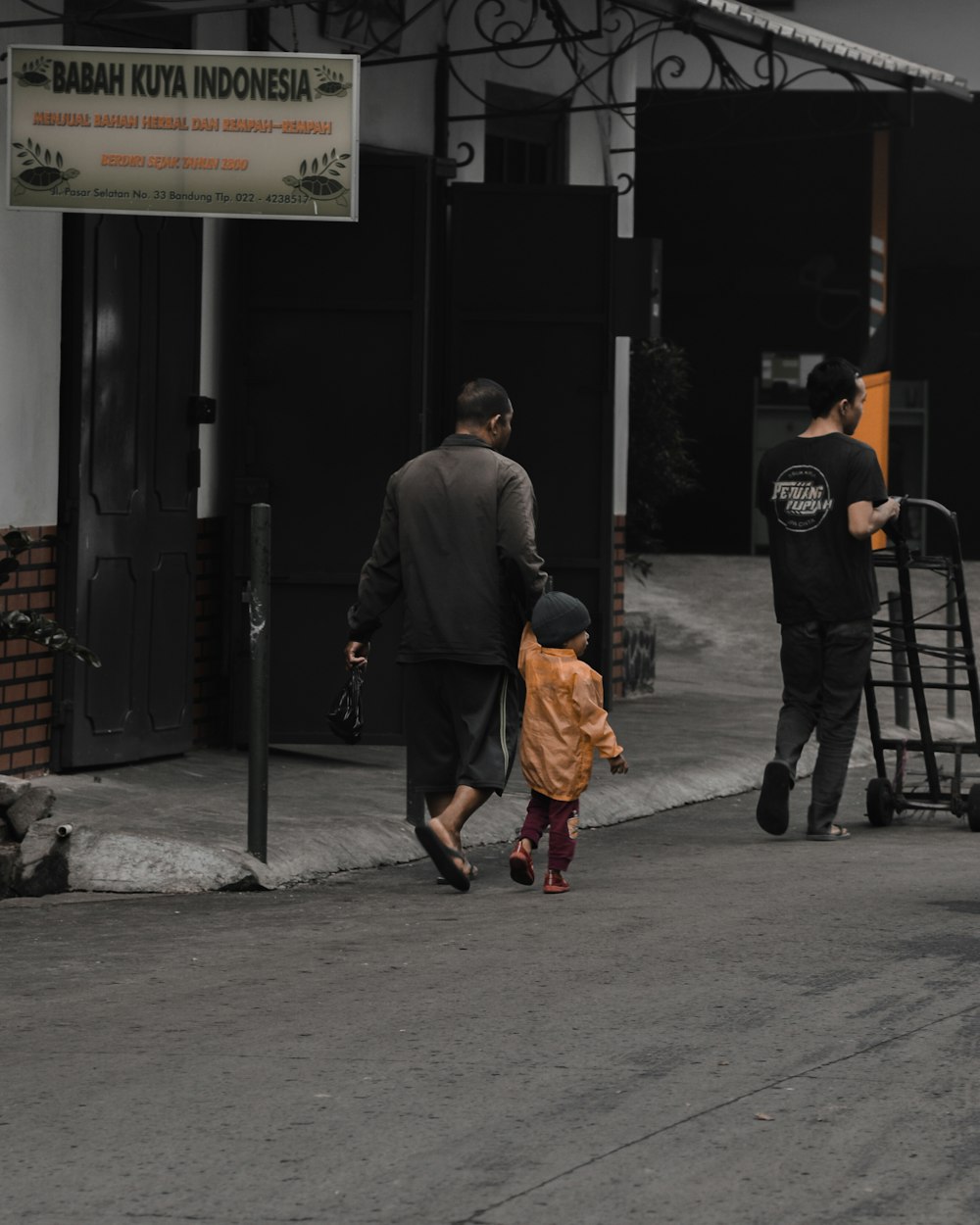 a man and a child walking down a sidewalk