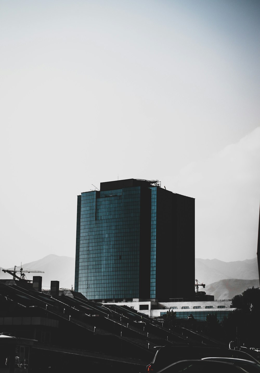 Un edificio alto con un puente frente a él