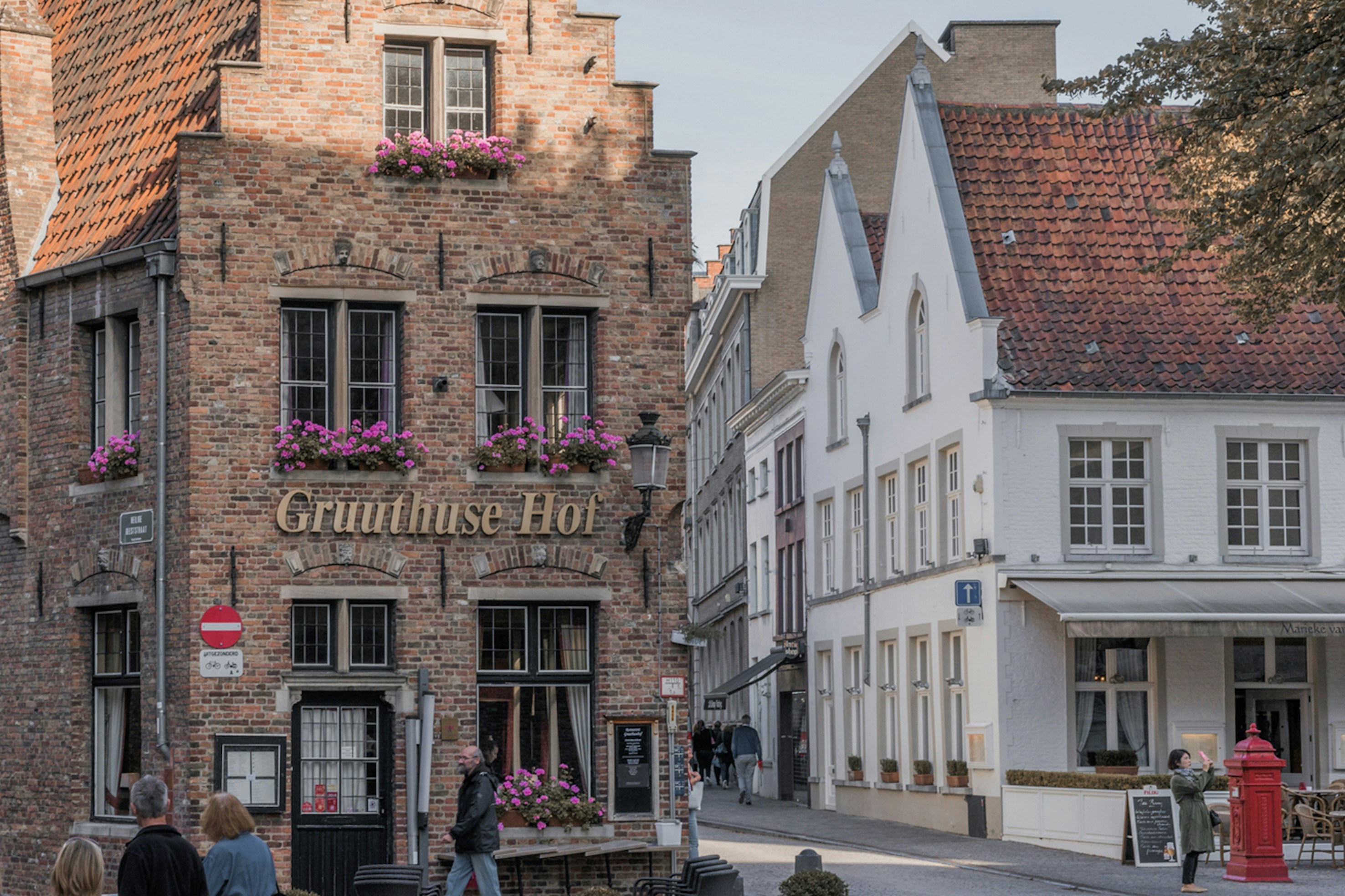 a group of people walking on a street between buildings