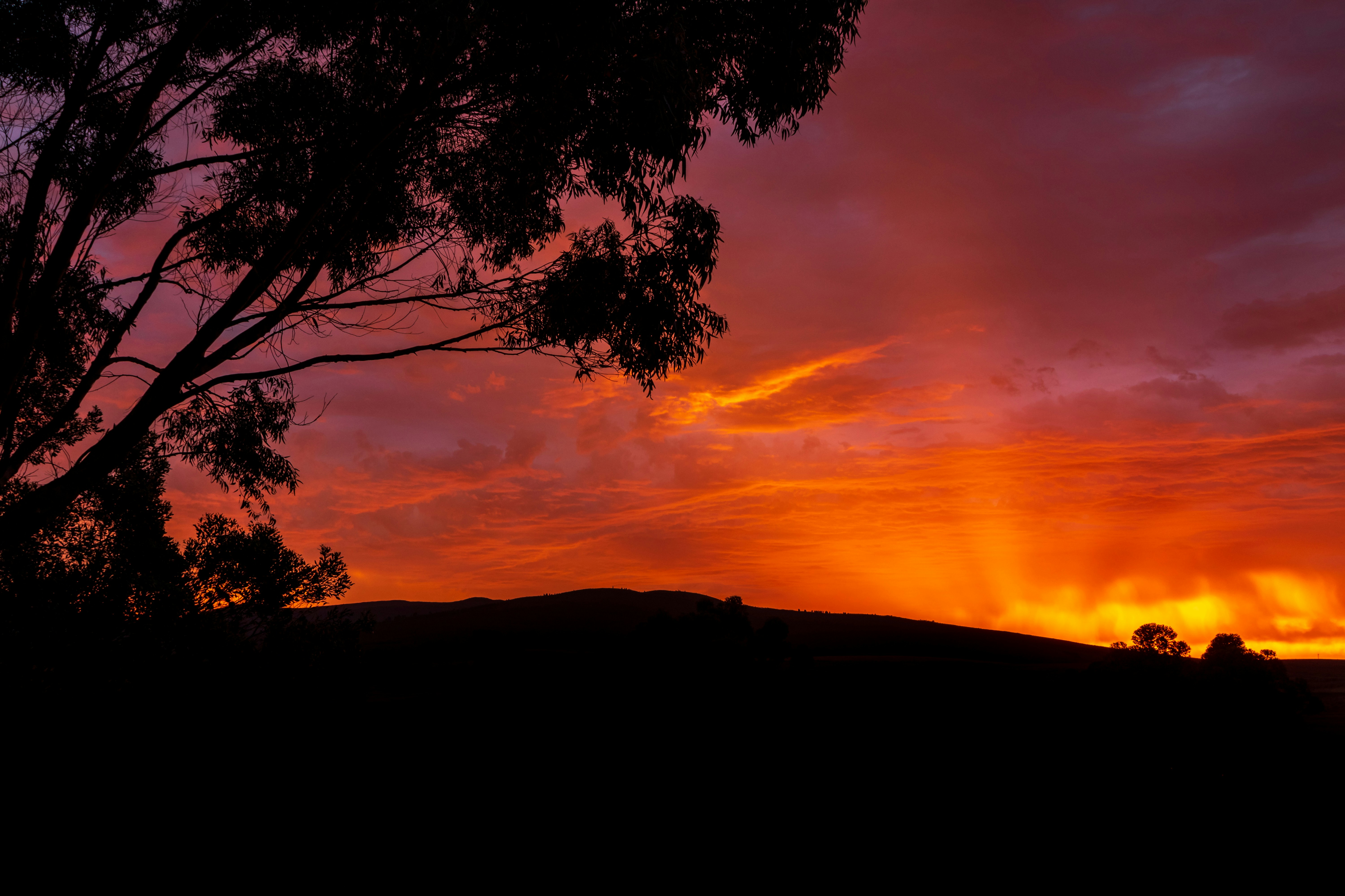 a sunset over a hill