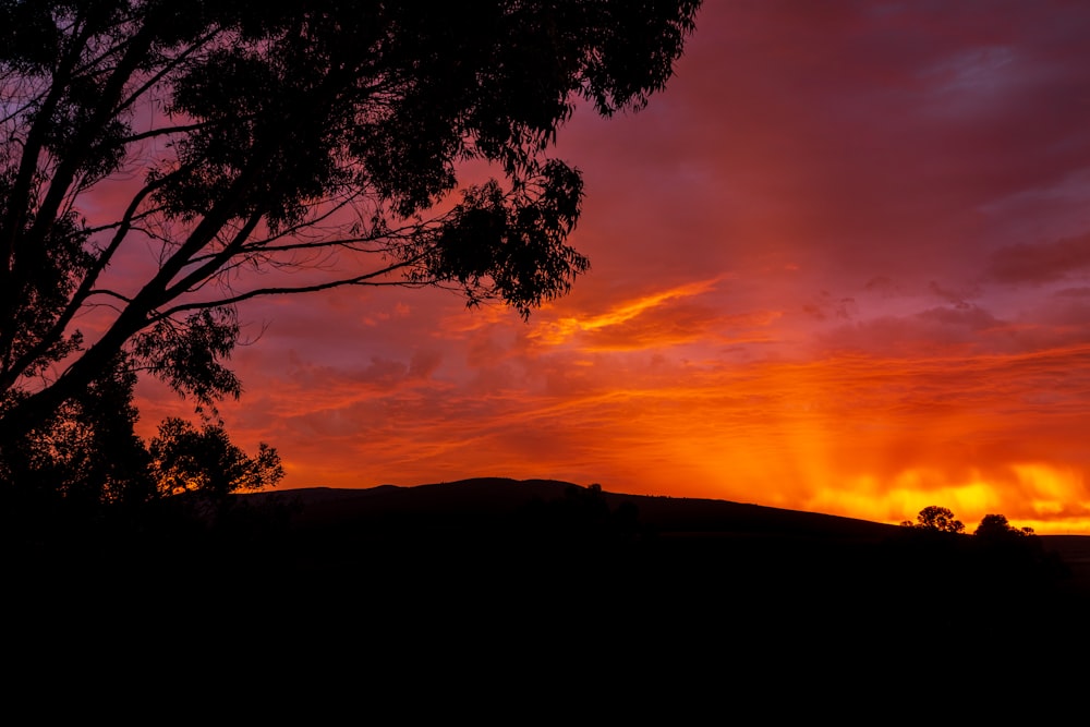 a sunset over a hill