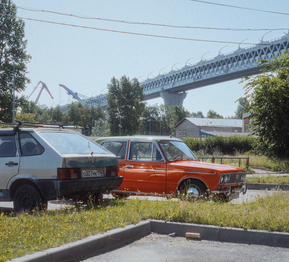 a couple of cars parked in front of a bridge