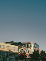 A completed commercial building with glass windows reflecting the sky.