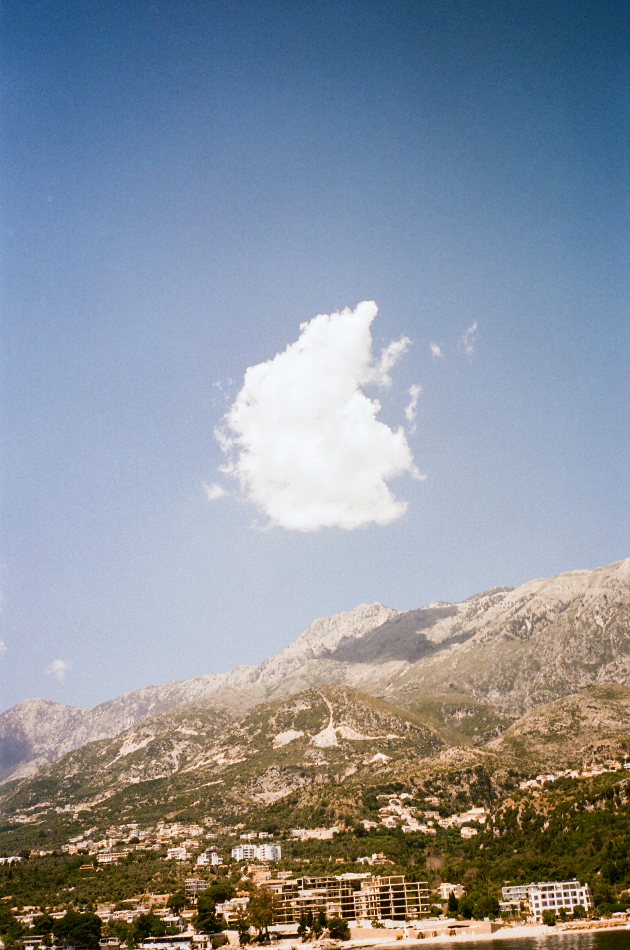 a large white cloud in the sky above a town
