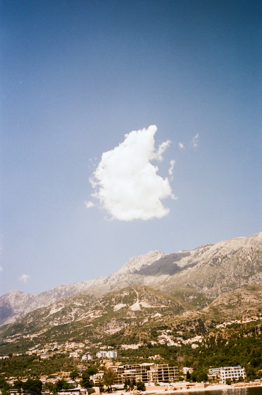 a large white cloud in the sky above a town