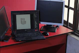 A sleek graphic design workspace showing branding materials and a laptop in action.