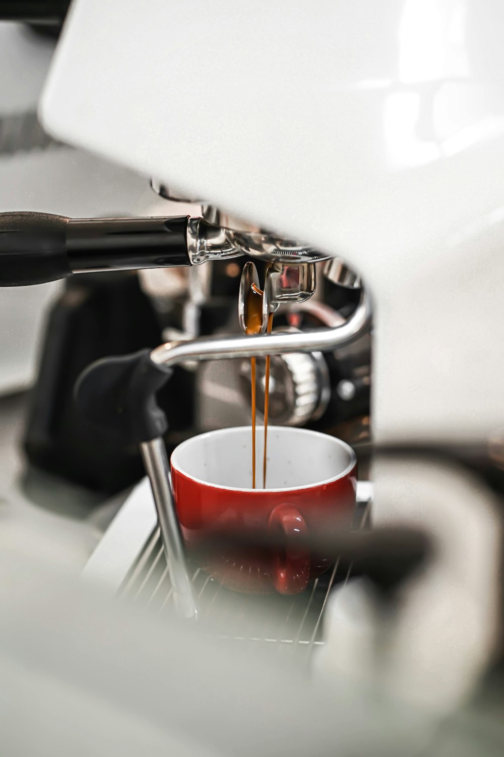 a cup of coffee being poured into a cup