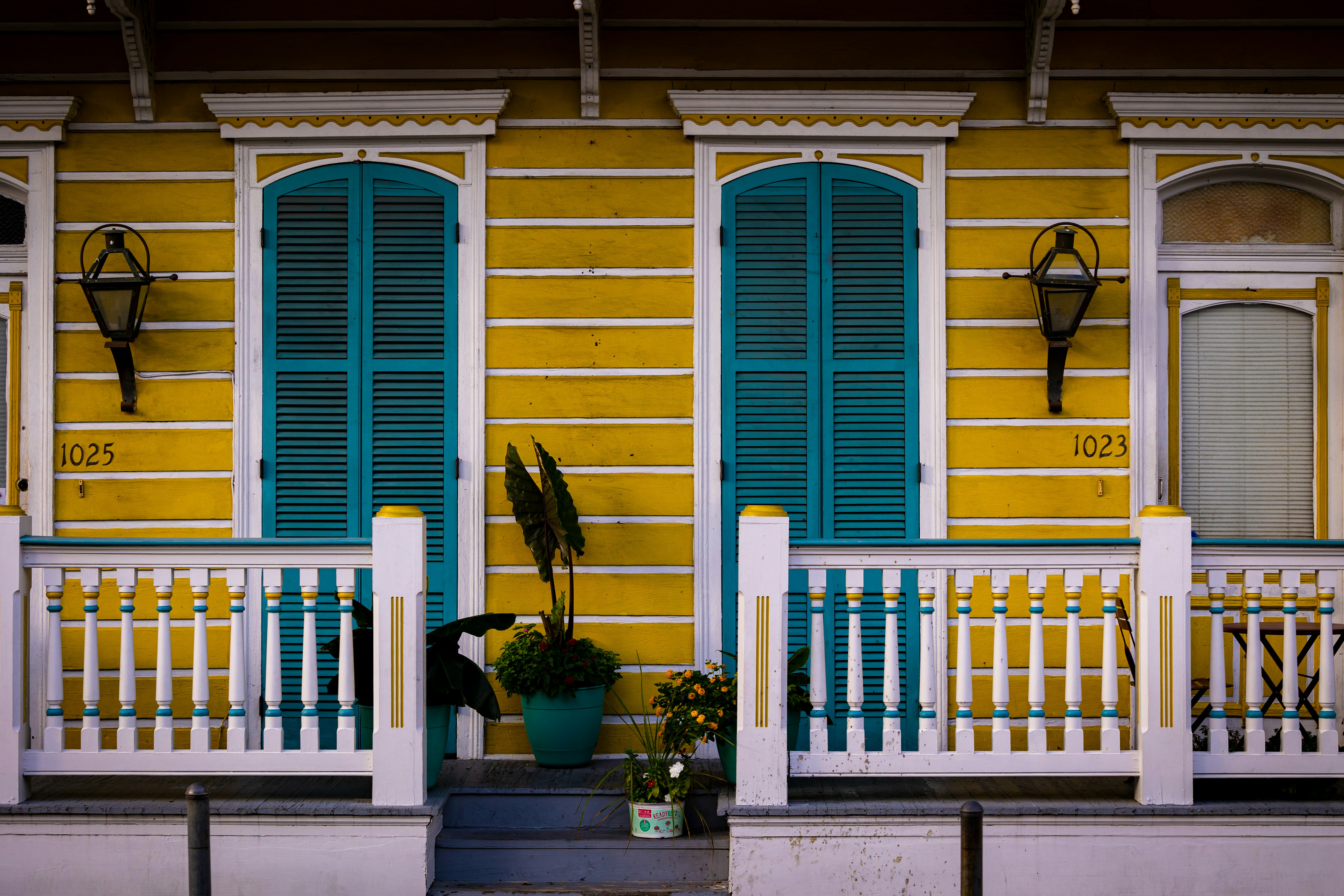 a yellow and blue house with a white fence and a white picket fence