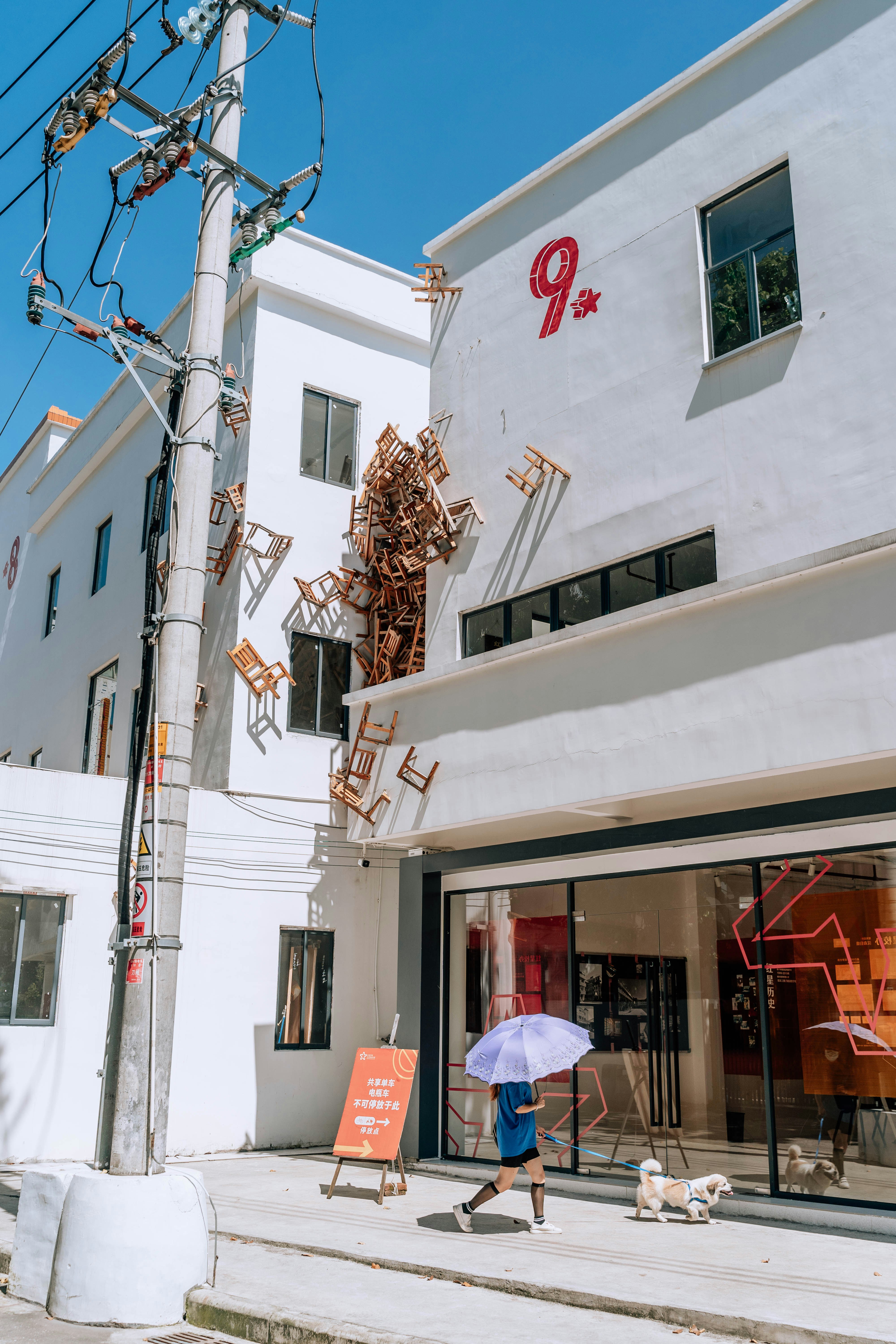 Eine Person geht mit einem Regenschirm einen Bürgersteig entlang