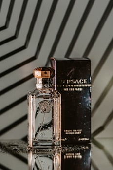 Elegant Versace fragrance bottle resting on a marble surface with gentle shadows.