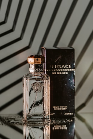 Close-up of a Versace fragrance bottle with golden accents reflecting a warm glow.