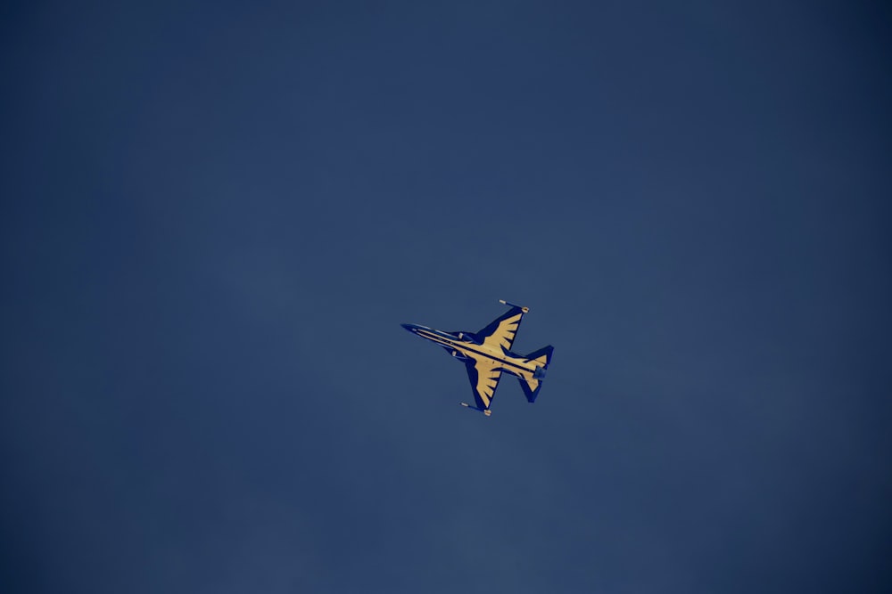 a blue and white airplane flying in the sky
