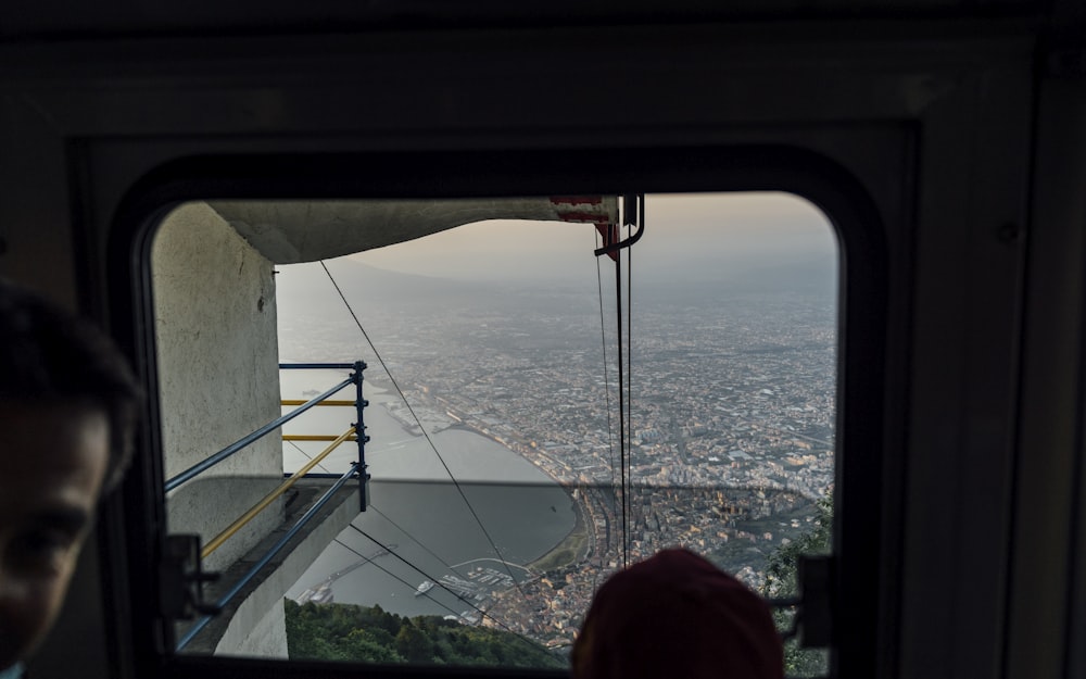 a person looking out a window at a city