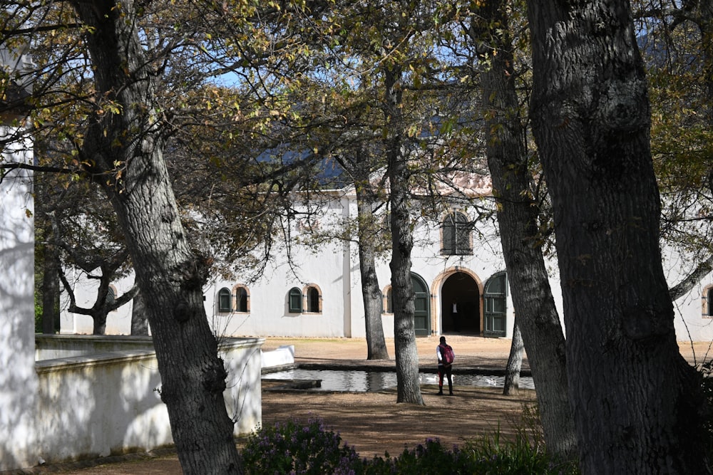 a person walking in front of a white building