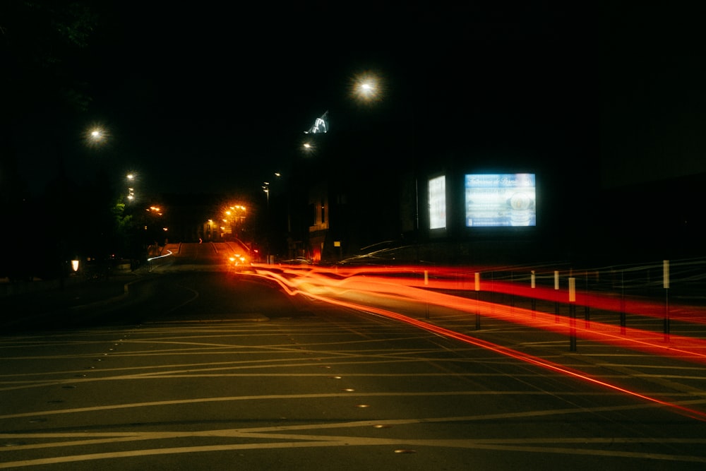 a road with a billboard and a fence at night