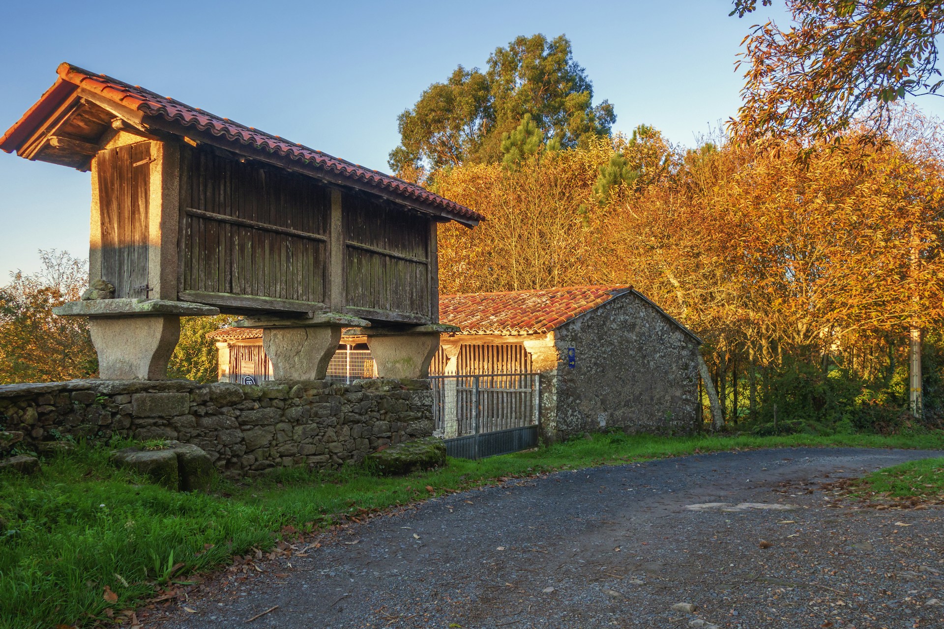 a stone building with a stone wall and a stone wall with trees