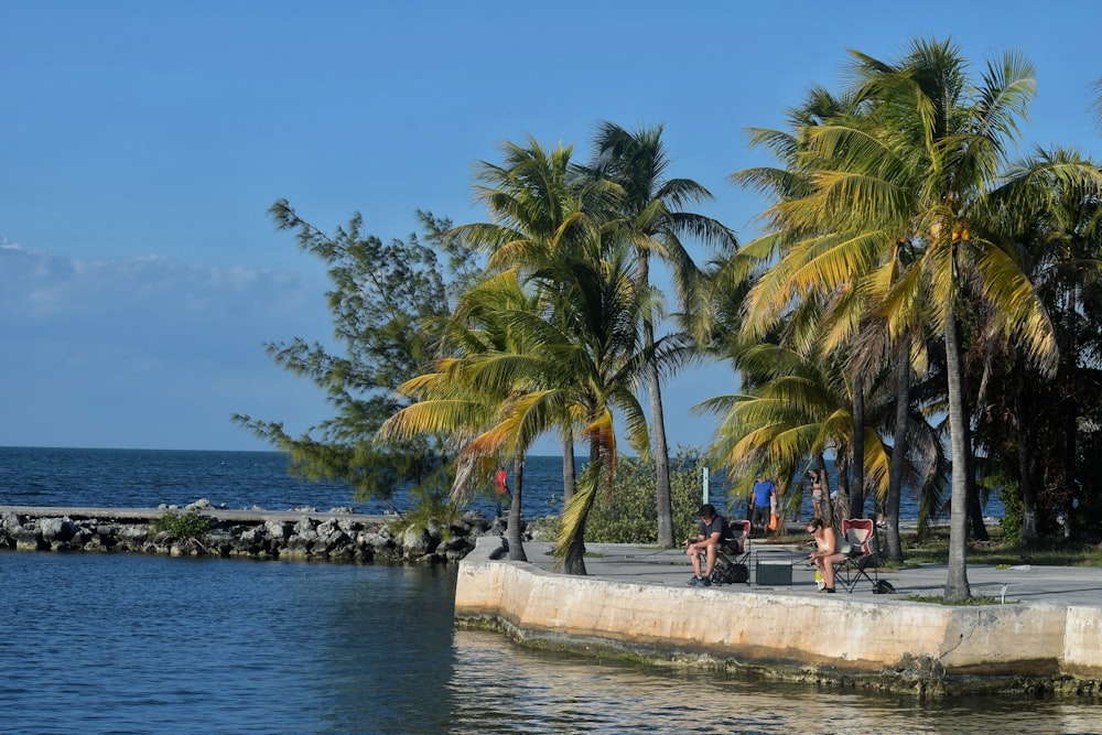 a group of people sitting on a bench by a body of water