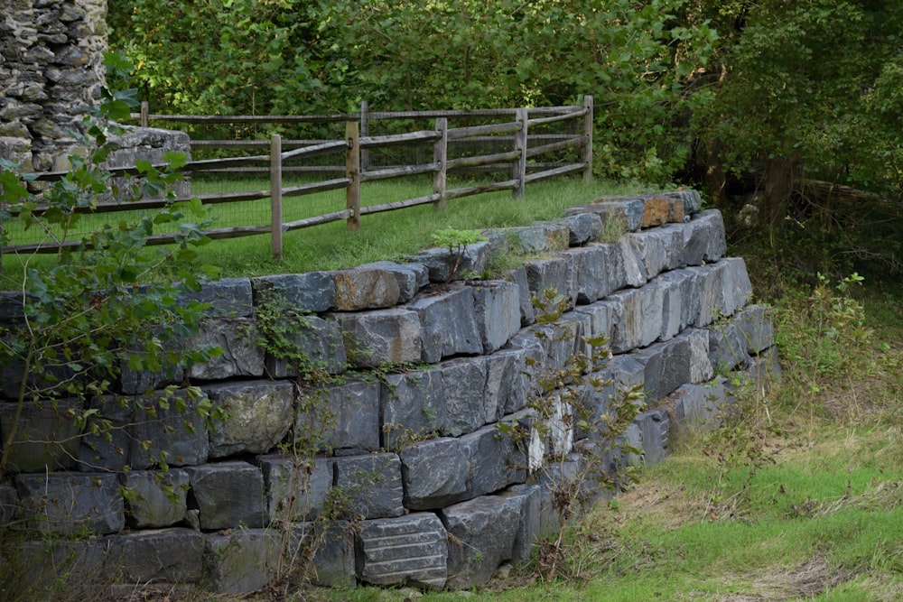 a stone wall with a fence