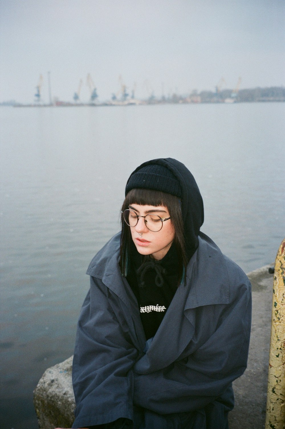 a person standing by a body of water with a city in the background