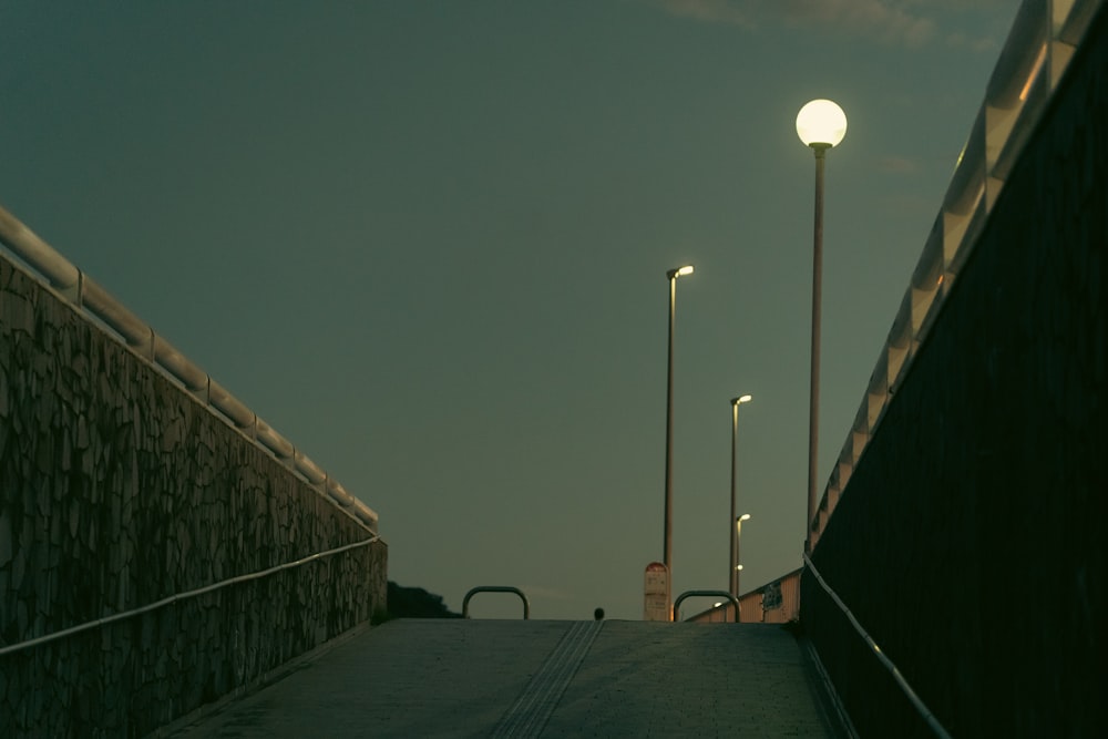 une passerelle avec un lampadaire et un mur avec une lumière dessus