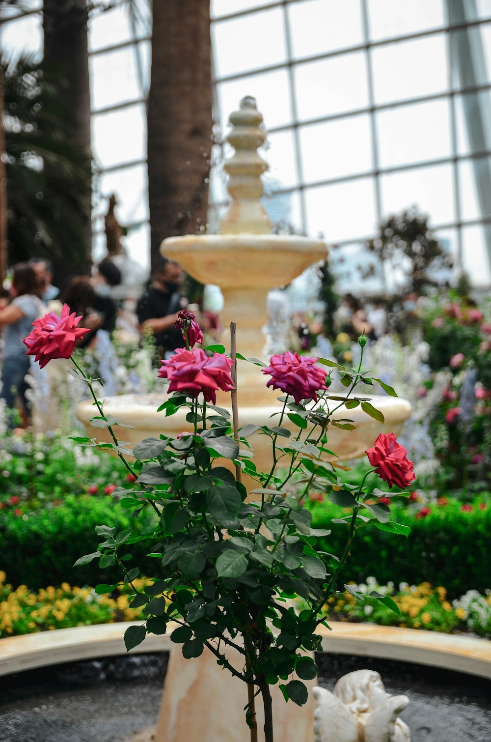 a fountain with flowers in front of a building