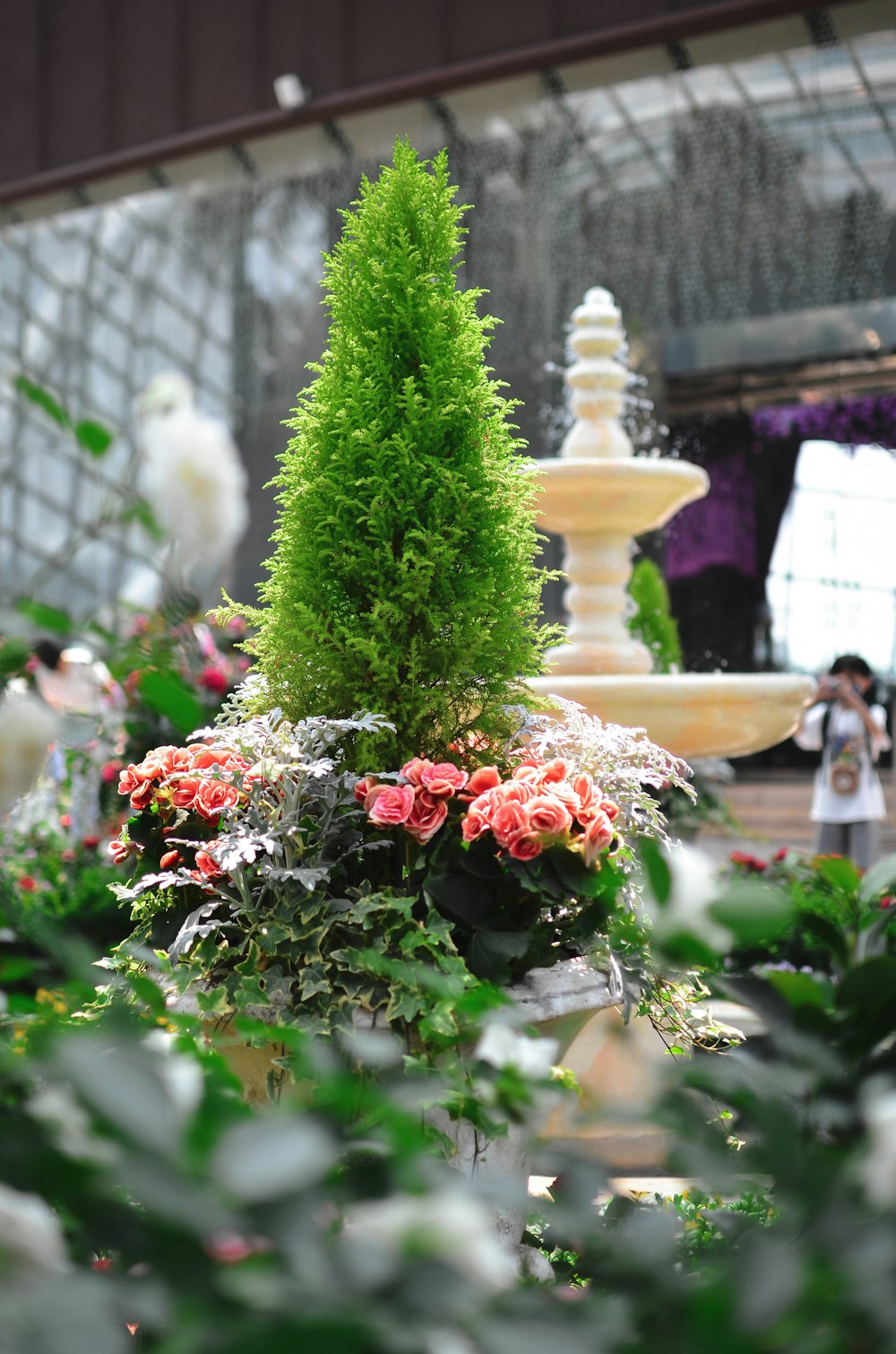 a fountain with flowers in front of it