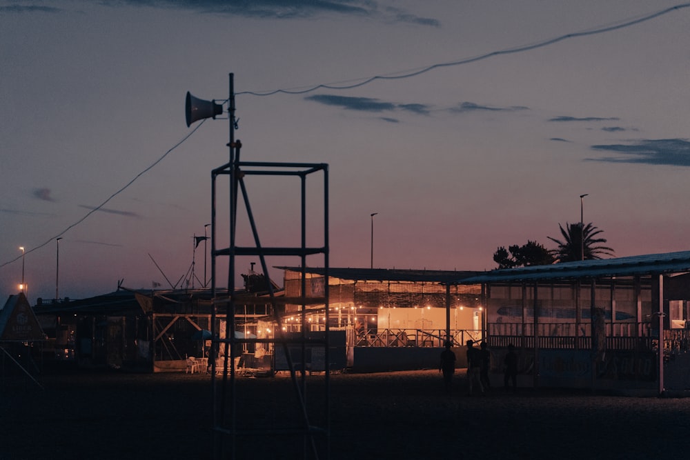 a group of people standing next to a building with a sunset