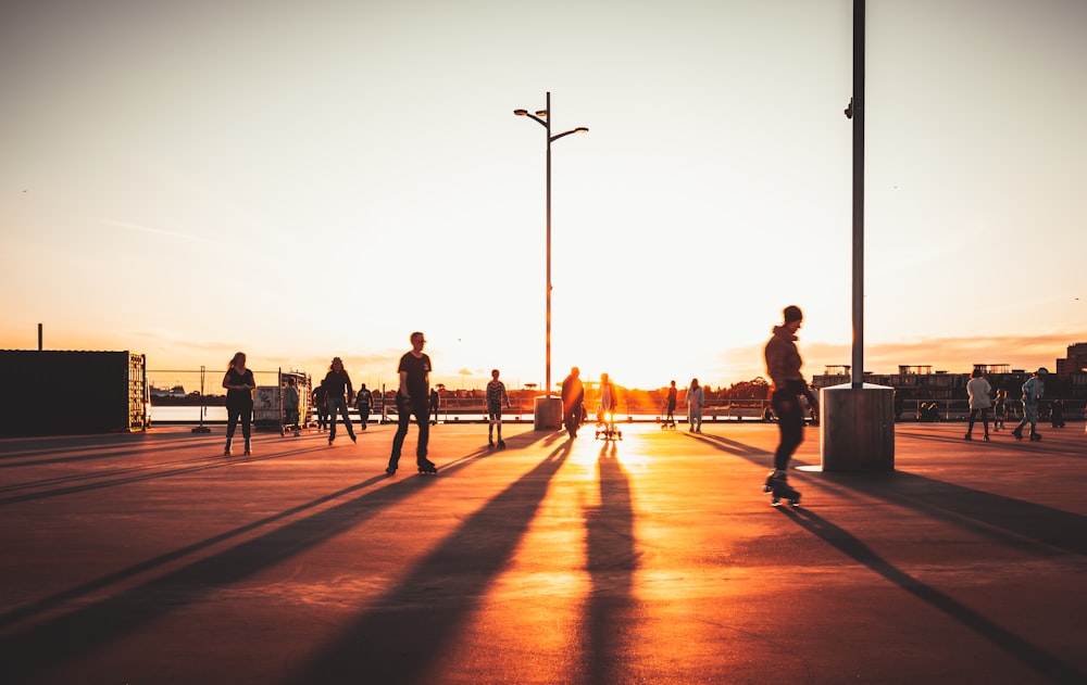 a group of people skateboarding at sunset