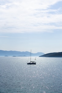 A serene boat sailing on calm waters under a bright sky, with a GPS route overlay.