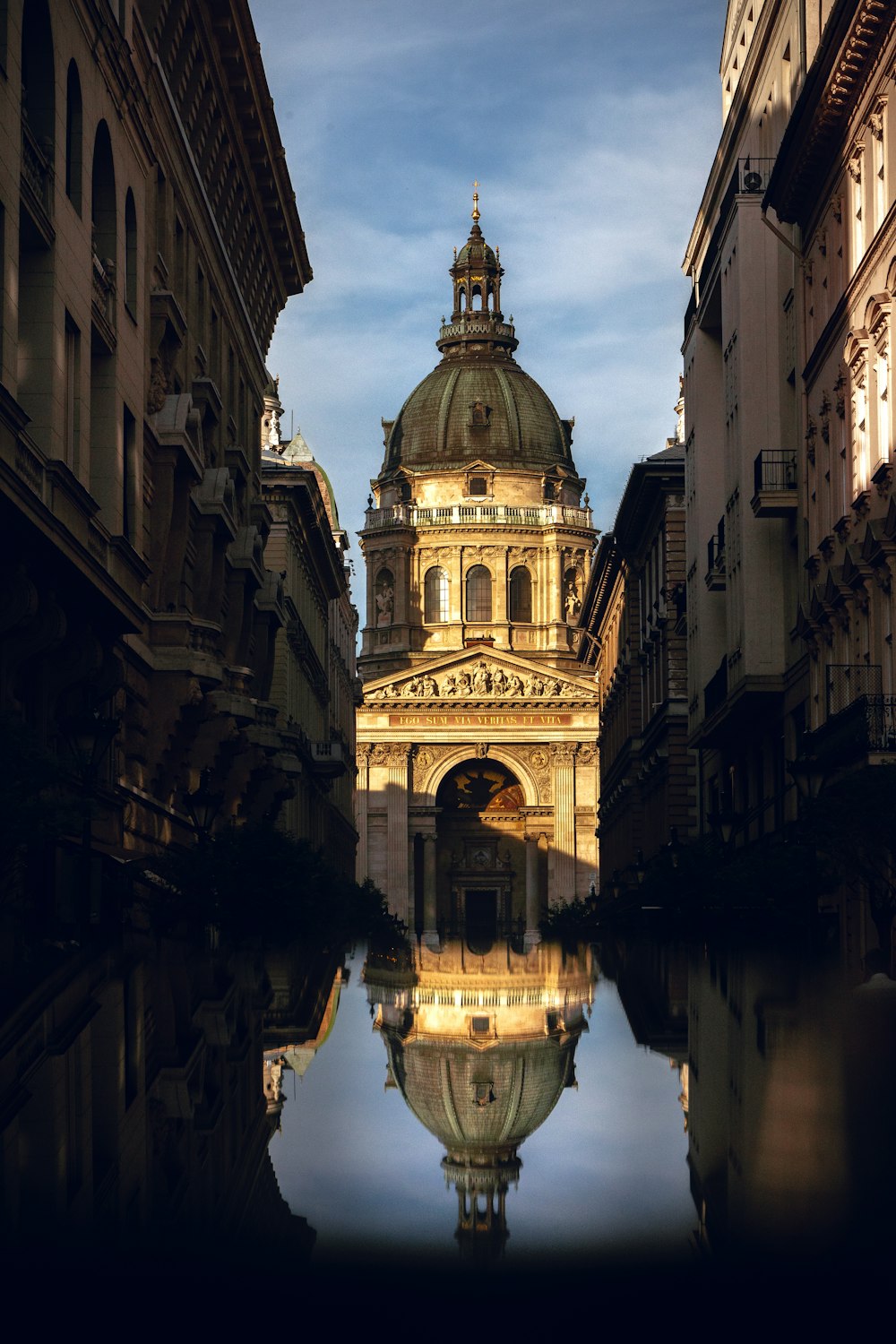 a reflection of a building in a puddle of water